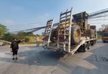 Vrachtwagenchauffeur met bouwmachines rijdt 11 elektriciteitspalen omver, beschadigt huizen in Chonburi, chauffeur geeft de schuld aan de hoogte van de draad
